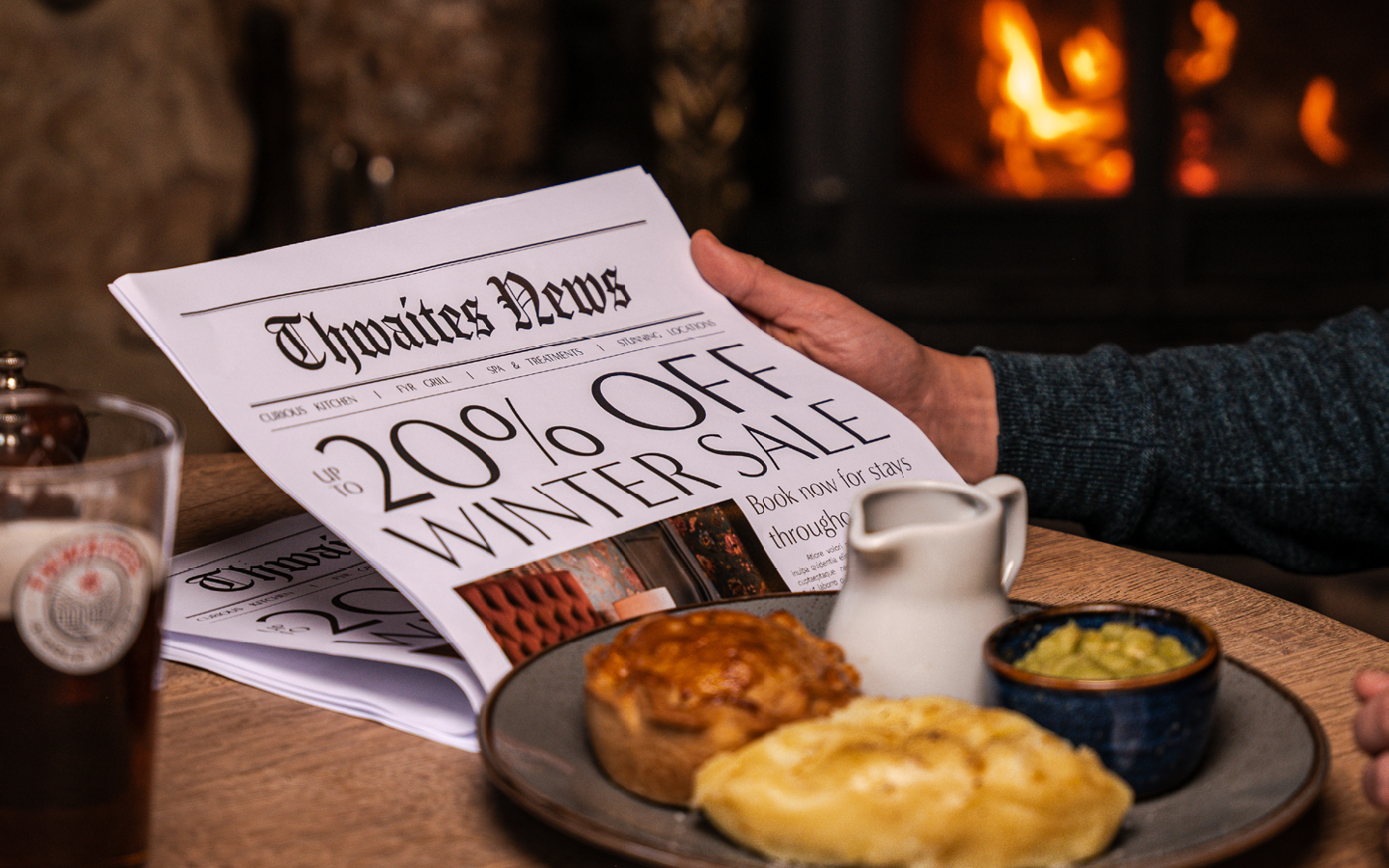 "up to 20% off this winter" newspaper with pie and a pint at a pub table
