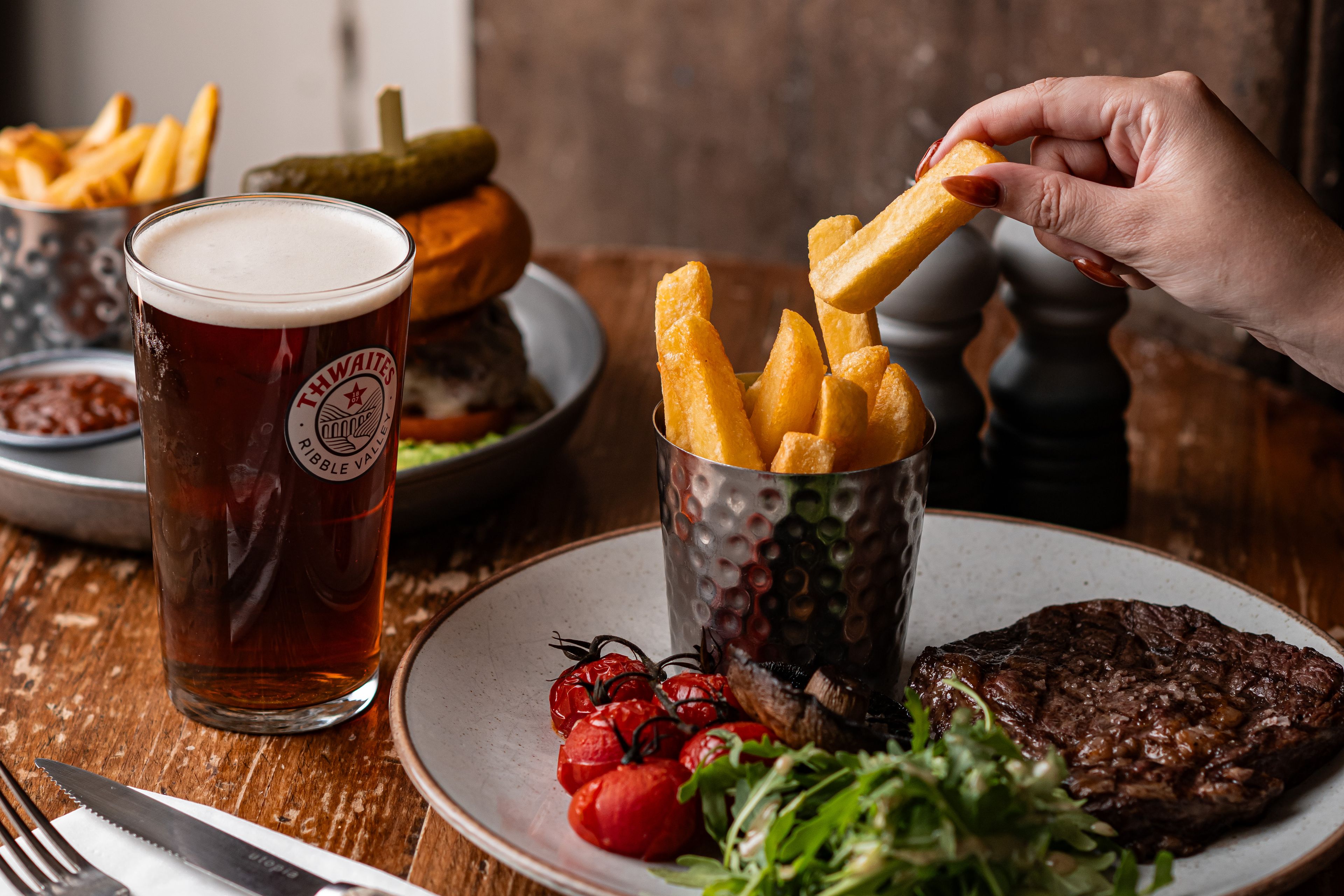 steak and chips dish with a pint of thwaites ale